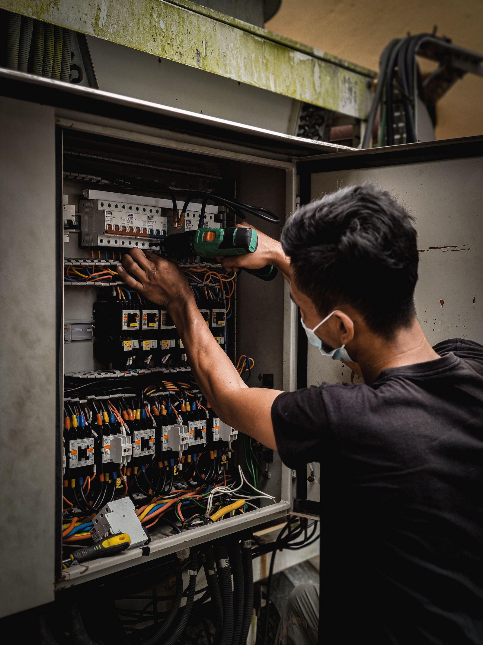Elettricista al lavoro su un quadro elettrico